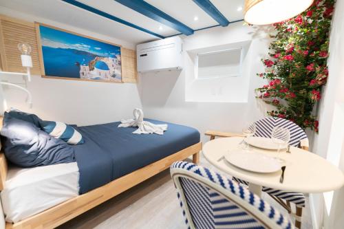 une petite chambre avec un lit et une table dans l'établissement Les Suites d Ailleurs, à Nice