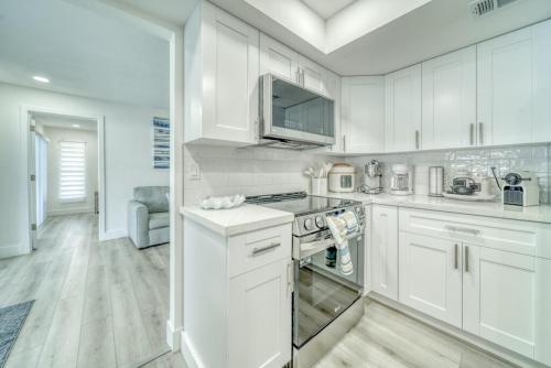 a kitchen with white cabinets and a stove top oven at Kids-Friendly Central Cape Coral Gem in Cape Coral