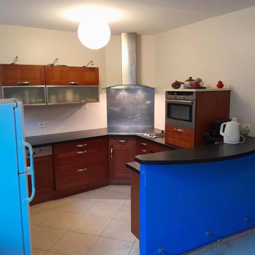 une cuisine avec des placards en bois et un îlot bleu dans l'établissement Maison familiale charmante à Ingrandes, à Ingrandes