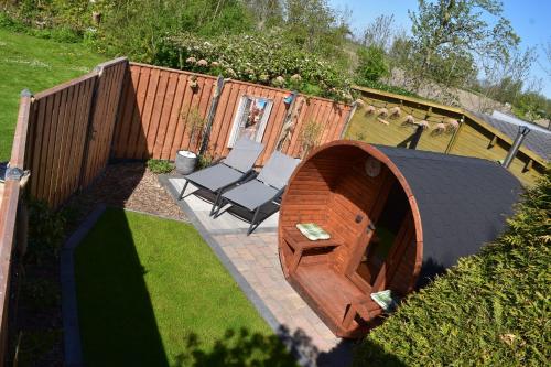 a patio with a table and two chairs in a backyard at Camping De Blauwe Reiger in Pieterzijl