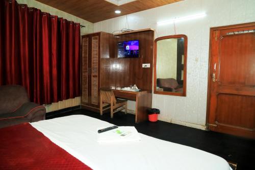 a bedroom with a bed and a desk and a mirror at Hotel New Royal Plaza in Chandīgarh