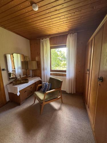 a bathroom with a sink and a chair and a mirror at Erholungsoase im Vorharz in Katlenburg-Lindau
