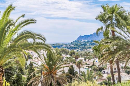 a view of a town with palm trees and mountains at Apt B Algemesi Moraira in Moraira