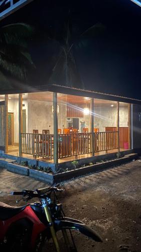 a building with a porch and a motorcycle parked in front at Lombok Grace Bungalows in Tetebatu