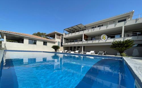une grande piscine devant un immeuble dans l'établissement La résidence Location Pinarello, à Mangialla