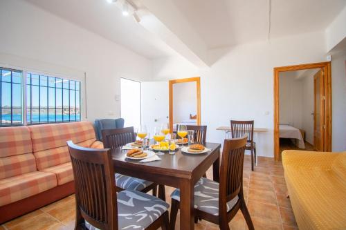 a dining room with a table and chairs and a couch at Terraza del Mediterráneo - By Aloha Palma in Calabardina
