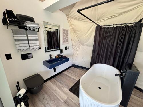 a bathroom with a tent with a tub and a sink at DayDreamer Domes in South Haven