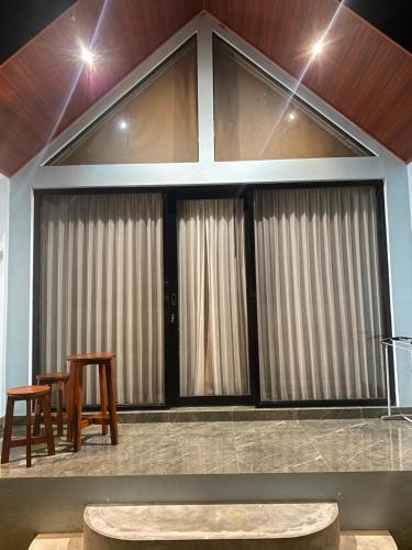 a room with two tables and two stools at Lombok Grace Bungalows in Tetebatu