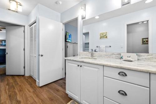 un bagno bianco con due lavandini e un grande specchio di Beach Daze Sanibel a Sanibel