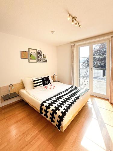 a bedroom with a large bed and a large window at Seehotel Schwert in Gersau