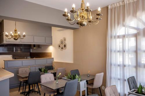 een eetkamer met tafels en stoelen en een kroonluchter bij Villa Klarić - Bed & Breakfast in Lovran