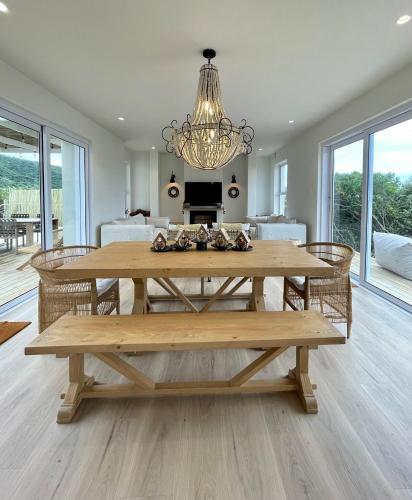 a dining room with a table and a chandelier at Fijnduin Beach House in Keurboomstrand