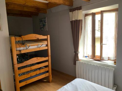une chambre avec un lit superposé et une fenêtre dans l'établissement Gîte Chez Charlot, à Chanaz