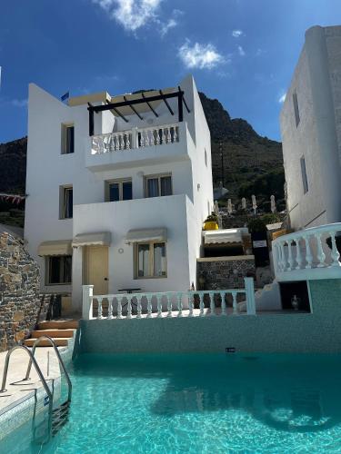 a building with a swimming pool in front of a house at Step into a world of nature One Room Private Suite shared pool in Hersonissos