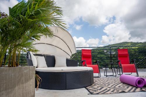 a patio with a couch and chairs and a table at Palms Rooftop Villa in Ocho Rios