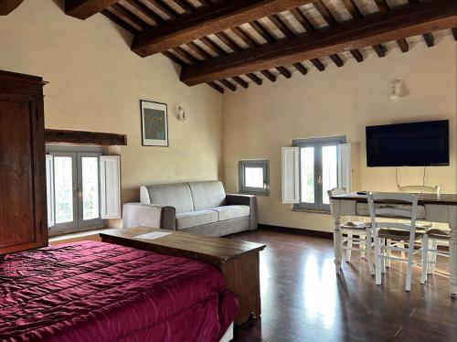 a living room with a bed and a couch and a table at Casale San Francesco d'Assisi in Assisi