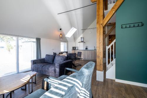 a living room with a couch and a table at Boerderijkamer de Hilde in Wijhe