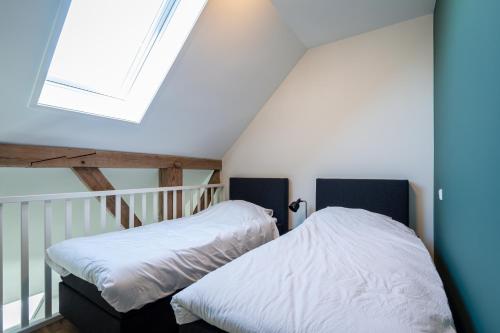a bedroom with a bed and a skylight at Boerderijkamer de Hilde in Wijhe