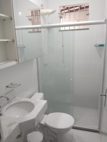 a bathroom with a toilet and a sink and a shower at Casa aconchegante in Feira de Santana