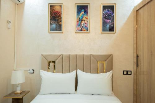 BenguerirにあるRiad Bollywood- UniStayのベッドルーム1室(壁に3枚の写真が飾られたベッド1台付)