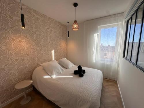 une chambre avec un lit blanc et une fenêtre dans l'établissement Le rocher, à Vitrolles