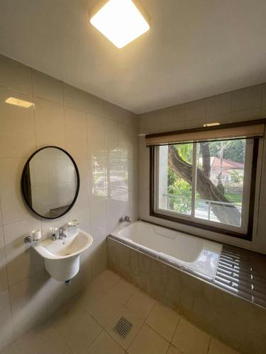 a bathroom with a sink and a tub and a window at 리젠시 풀빌라 in Sampong