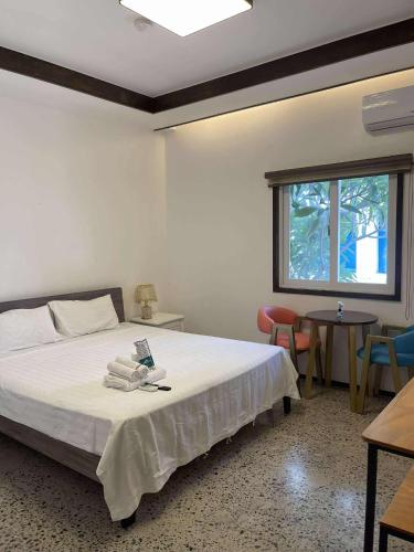 a bedroom with a bed and a window and chairs at 리젠시 풀빌라 in Sampong