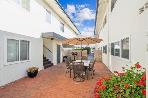a patio with a table and chairs and an umbrella at 1 Bed Beach Condo #131 in Carpinteria