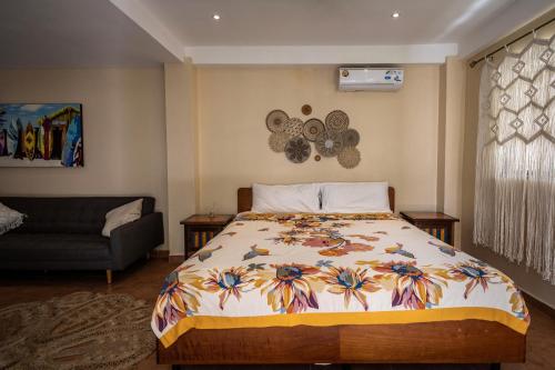 a bedroom with a bed and a couch at Seahouse Beachfront B&B with Pool in Bocas del Toro