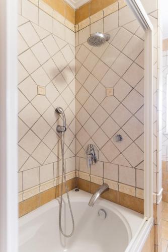 a shower with a bath tub with a shower head at Atrium Villa Syvota in Syvota