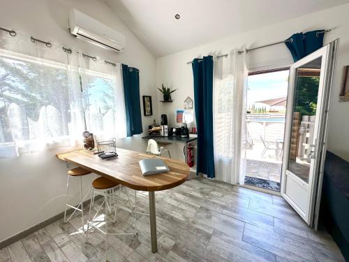 a dining room with a table and a laptop on it at Les Appartement du Mas - RUBIS in Aigues-Mortes