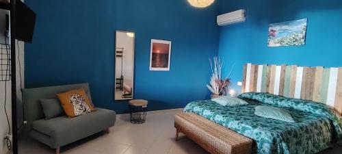 a bedroom with blue walls and a bed and a chair at Villa la Milanina in Lipari