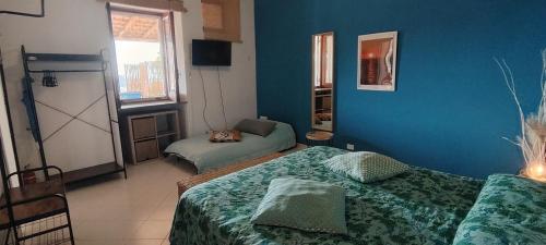 a blue room with two beds and a window at Villa la Milanina in Lipari