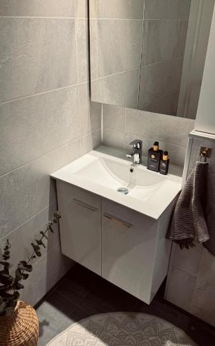 a bathroom with a white sink and a mirror at EideKollen in Tromsø