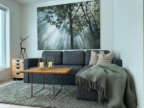 a living room with a blue couch and a table at EideKollen in Tromsø