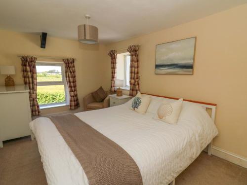 a bedroom with a large white bed and windows at Towyn Hall in New Quay