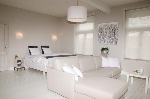 Biały salon z łóżkiem i kanapą w obiekcie De Pastorie - Zillebeke w mieście Ypres
