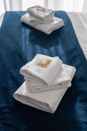 a pile of towels sitting on top of a bed at Divina Holiday - Rooms in Maiori