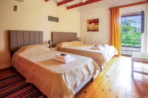 two beds sitting in a room with a window at Kamera House - 10 min to Seitan Limania Beach in Khordhákion