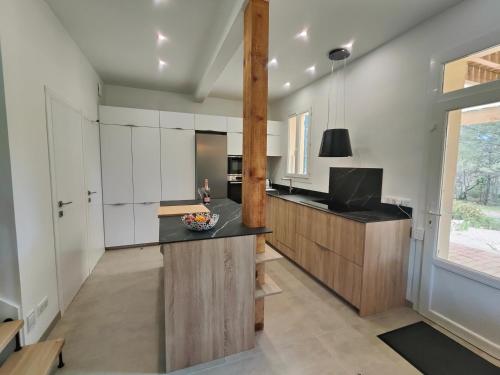 une cuisine avec des armoires blanches et un comptoir noir dans l'établissement Mas de Caussagues, la Presqu'ile, à Sigean