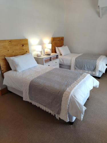 a hotel room with two beds and a room with two lamps at KarooRus in Burgersdorp