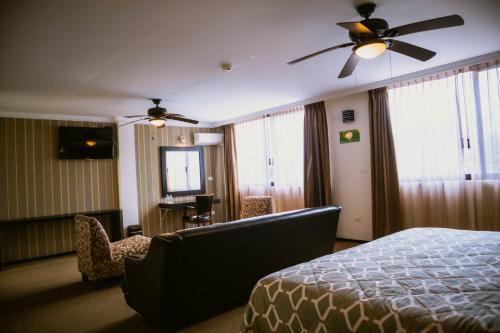 a hotel room with a bed and a ceiling fan at Hotel Clara Luna in Xalapa