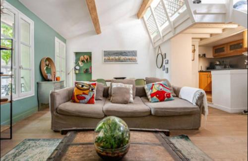 un salon avec un canapé et une cuisine dans l'établissement Aix-en-Provence : appartement de charme centre ville, à Aix-en-Provence