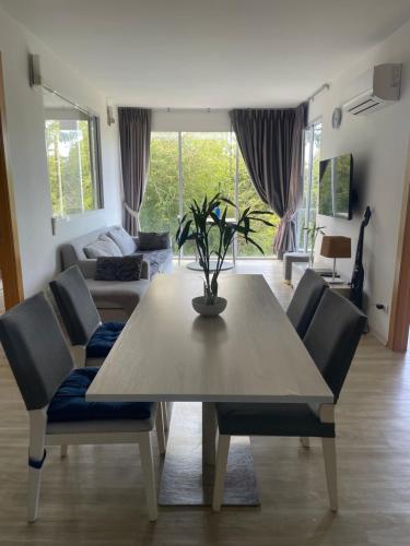 een woonkamer met een houten tafel en stoelen bij Le Grand Bleu in Koh Samui 