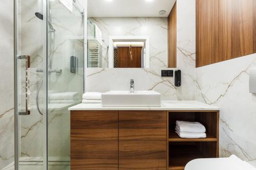 a bathroom with a sink and a shower at Stegna Gold Amber Apartment in Stegna