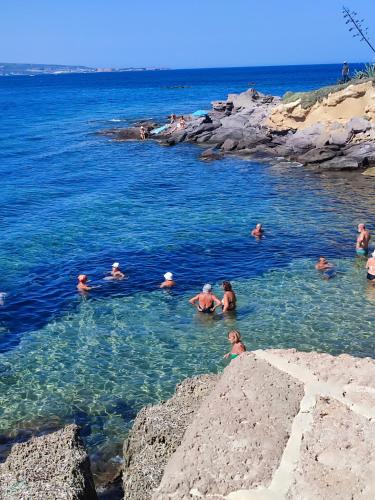 a group of people swimming in a body of water at Casa al mare Portoscuso in Portoscuso