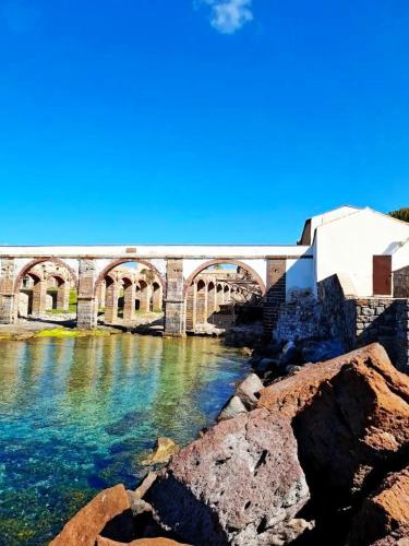 a bridge over a river with rocks in the foreground at Casa al mare Portoscuso in Portoscuso