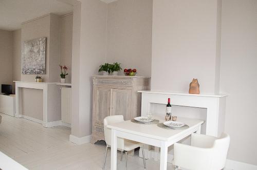 a white dining room with a white table and chairs at De Pastorie - Zillebeke in Ieper