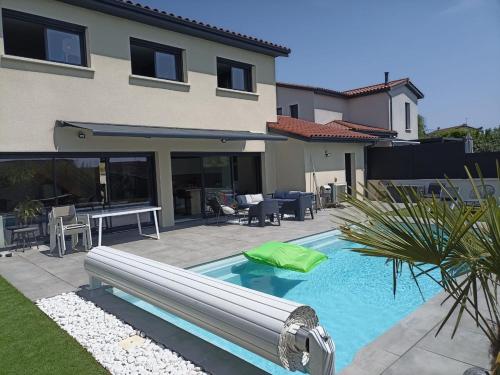 une piscine devant une maison dans l'établissement Maison avec piscine, jardin et barbecue, à Craponne