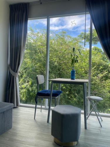 een kamer met een tafel en stoelen en een groot raam bij Le Grand Bleu in Koh Samui 